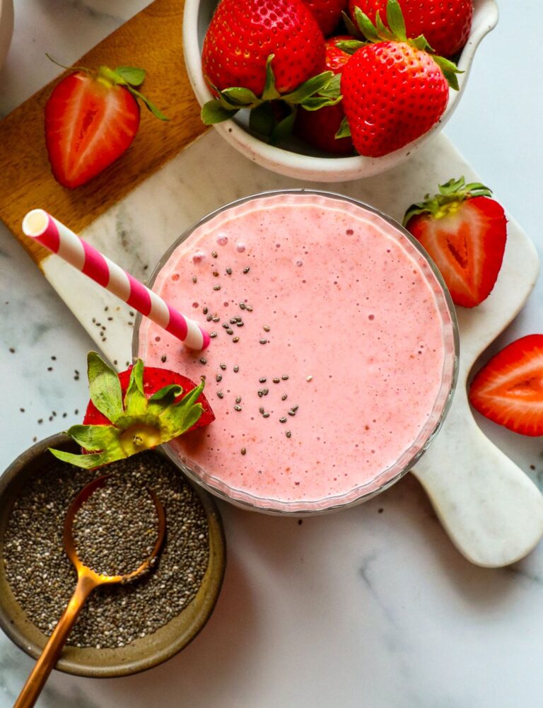 fruit smoothie with chia seeds on top in a glass. 